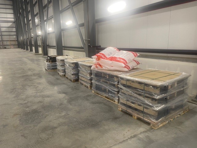 Pallets in a row containing parts for the automated storage and retrieval system.