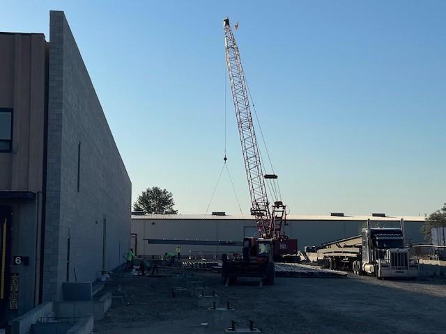 Steel beams and columns are being positioned for the warehouse expansion.