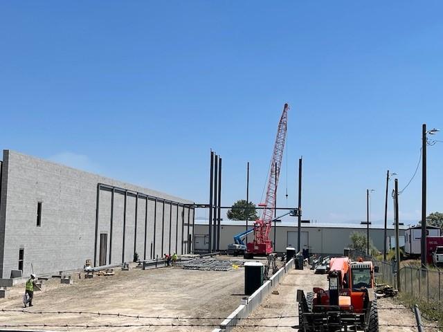 Steel framework of the liquor warehouse expansion rising tall next to the existing building.