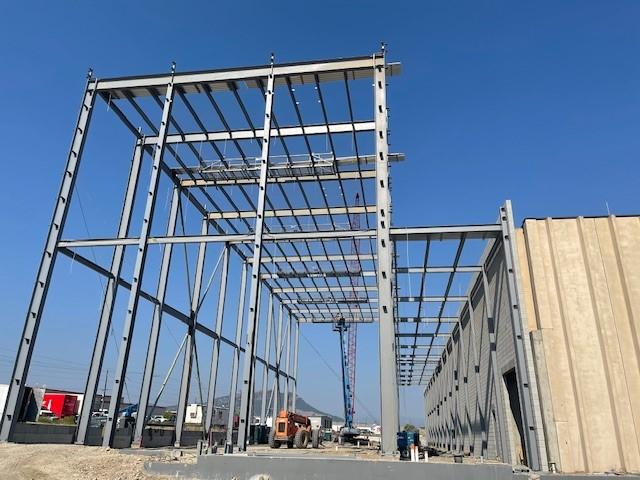 A crane assists in erecting the steel structure of the liquor warehouse expansion