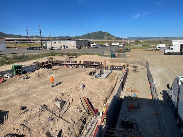 An overview of the construction site showing a foundation being prepared.