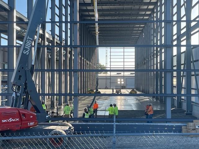 Inside view of the warehouse under construction, with steel beams and open framework.