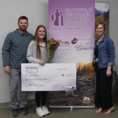 Zoe Axtman with her parents while holding a scholarship check