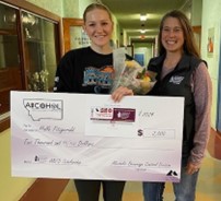 Halle Fitzgerald receiving a scholarship check and a bouquet of flowers