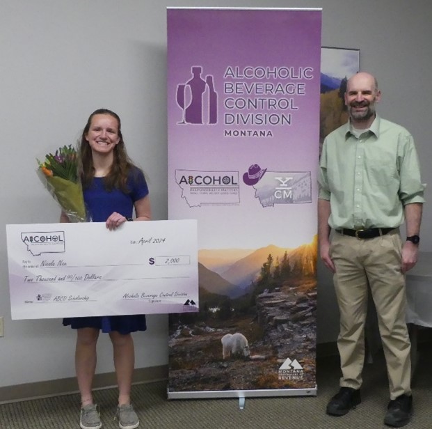 Nicole Nau with her father holding a bouquet of flowers and scholarship check