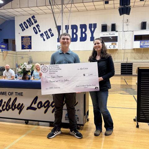 Teague Thompson at the scholarship ceremony at Libby High School receiving oversized check.